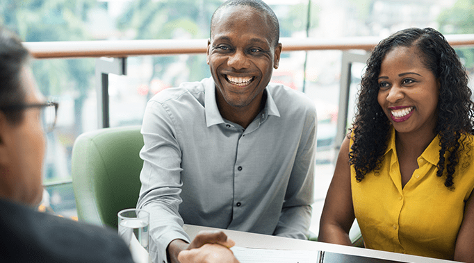 couple shaking hands with broker